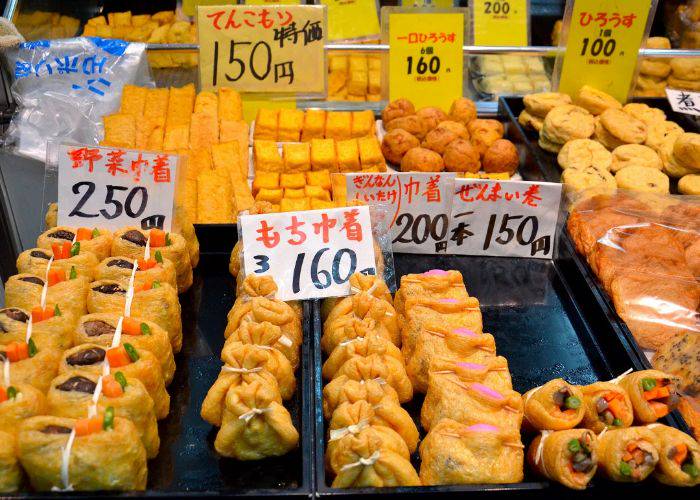 Street food in Kuromon Market, showing off a variety of fried tofu goods.